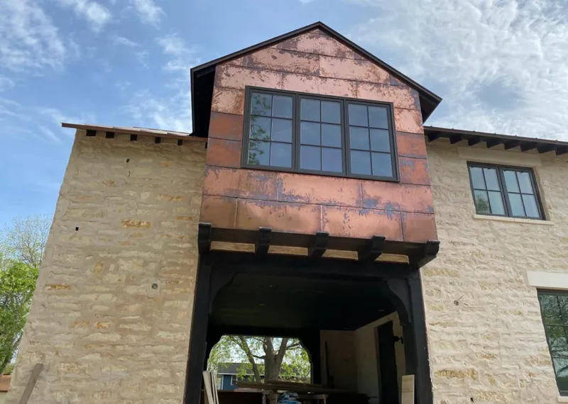 Copper metal panel facade on a stone building for Roof Repair in Borger