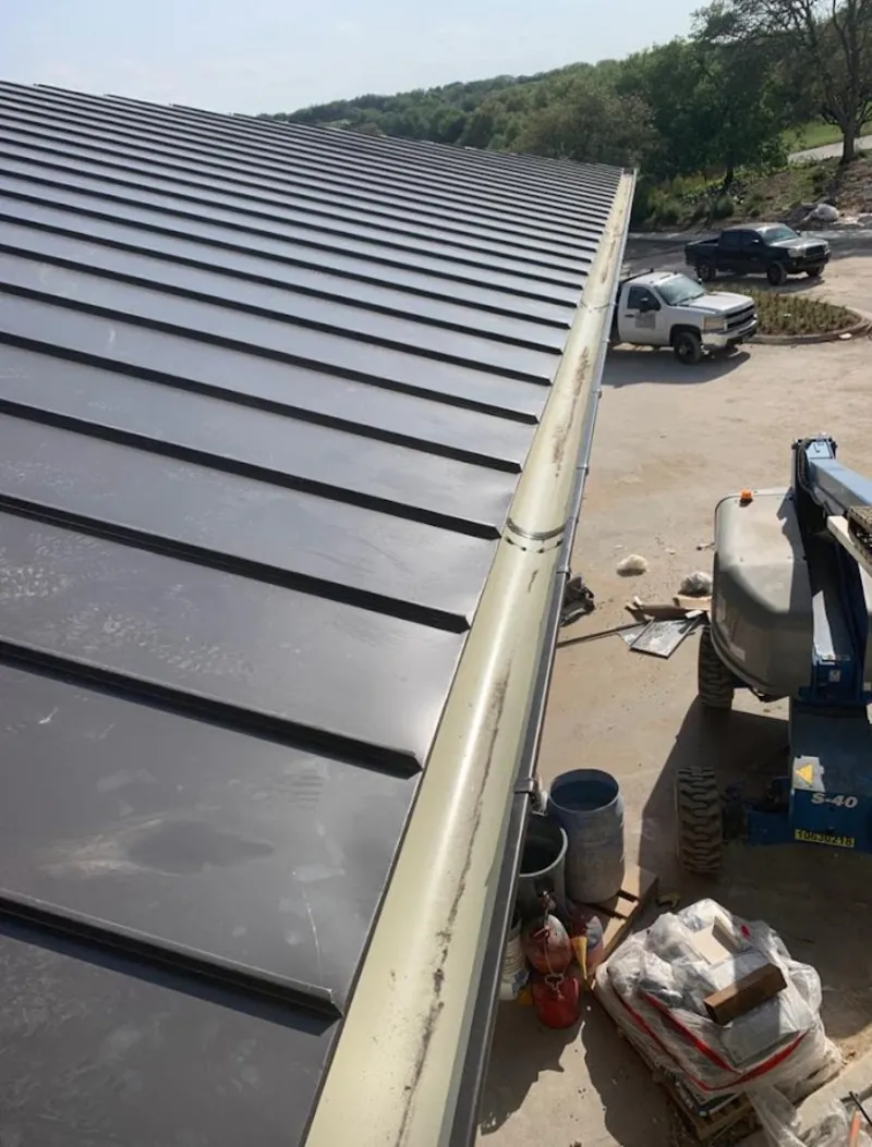 Standing seam panel and gutter detail on a metal roofing jobsite in Borger